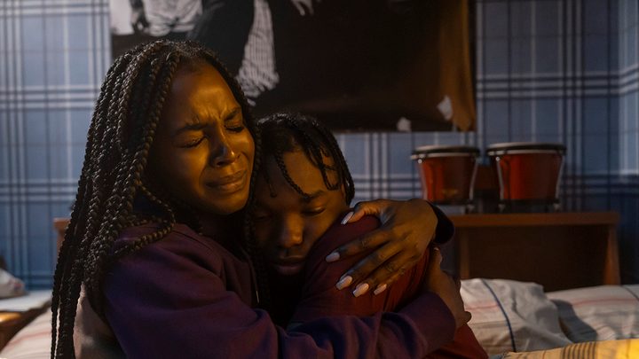 A woman hugs a child tight, both looking terrified in Them: The Scare.