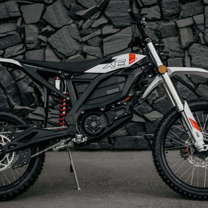 2025 Zero XE right profile with a dark gray rock wall background.