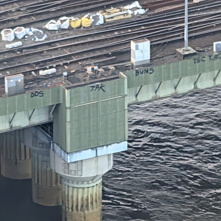 Photo taken at 30x zoom on the Google Pixel 9 Pro showing graffiti on the side of a bridge in London.