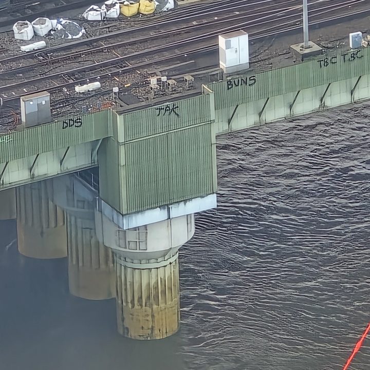 Photo taken at 30x zoom on the Samsung Galaxy S24 Ultra showing graffiti on the side of a bridge in London.