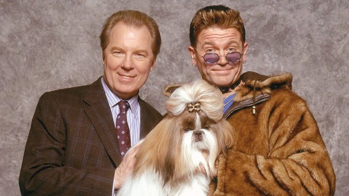 Two men pose with their dog in Best in Show.