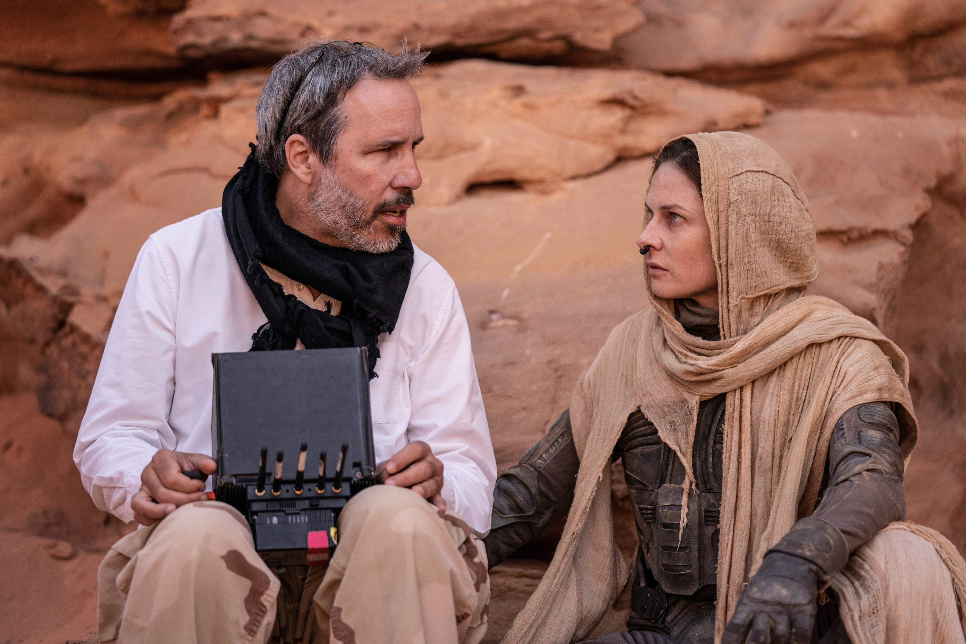 Denis Villeneuve sitting with Rebecca Ferguson on the set of "Dune: Part Two."