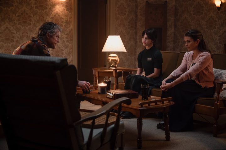 Hugh Grant sits across from Sophie Thatcher and Chloe East in Heretic.