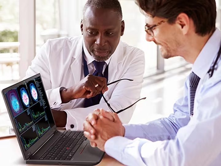 Two people collaborate at a desk with the Lenovo ThinkPad P16v Gen 2.