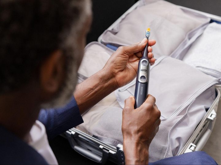 Man taking Soocas electric toothbrush out of luggage