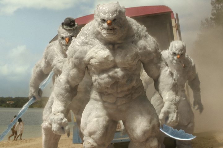 Monstrous snowmen stand on a beach in Red One.