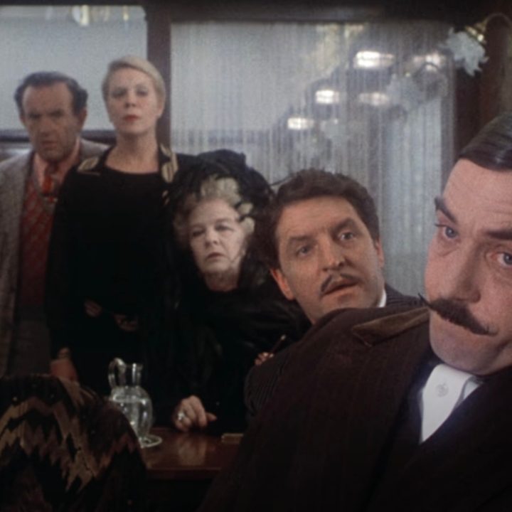 The cast of 1974's "Murder on the Orient Express" sitting in a train car together.
