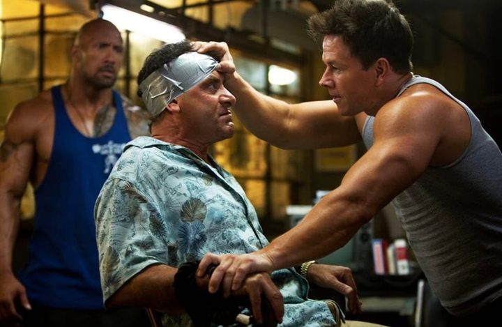A man puts his hands against someone's head sitting down.