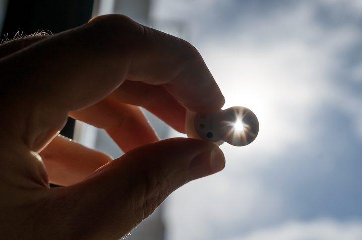 Sun shining through opening in Sony LinkBuds Open earbud.