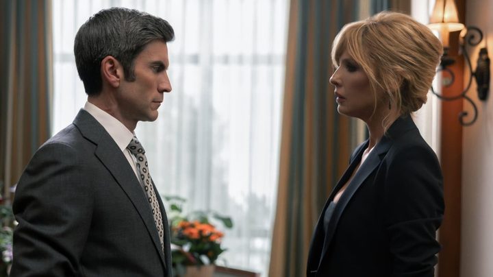 A man and woman stand across and face each other.