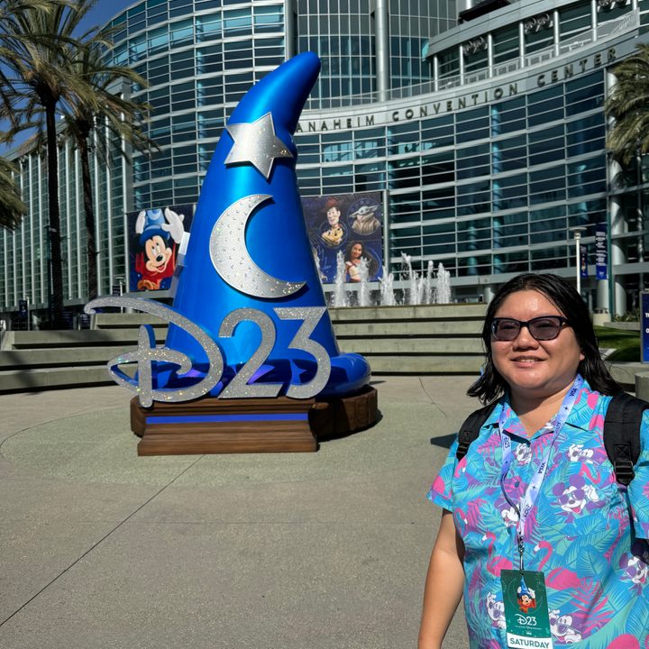 A person standing in front of the D23 display at Anaheim Convention Center.