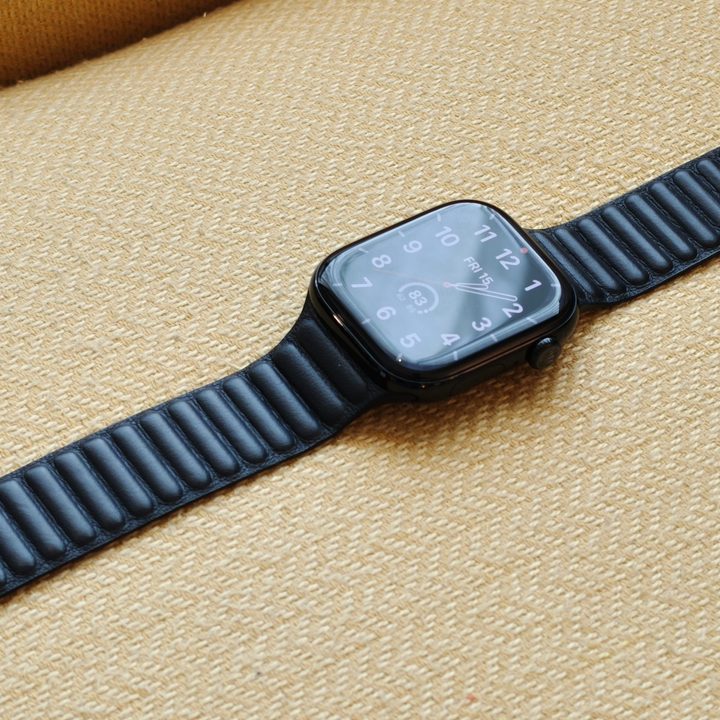 The Apple Watch Series 10, with a leather band, laying on a yellow chair.