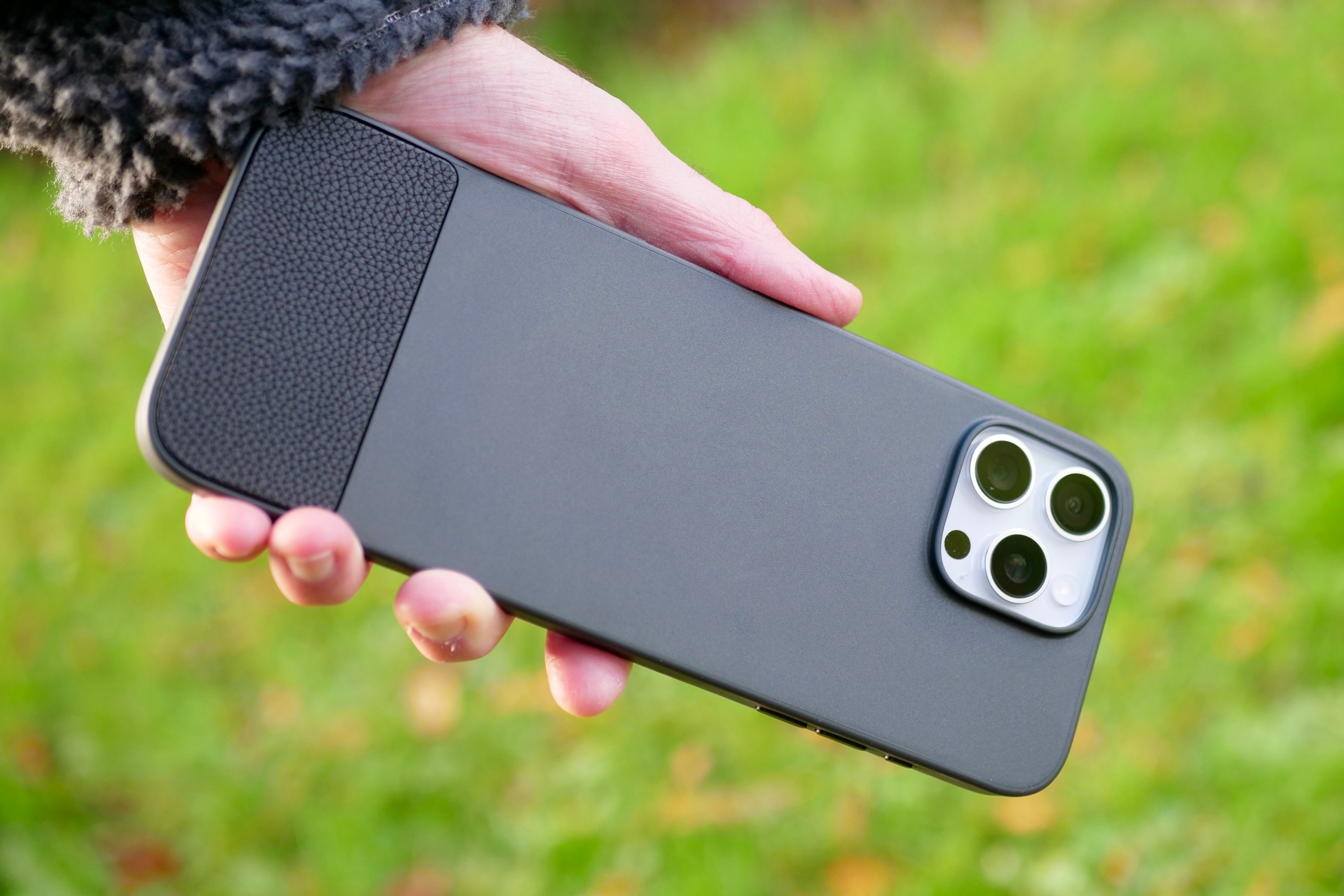 A person holding an iPhone 16 Pro Max inside the Clicks Keyboard case.