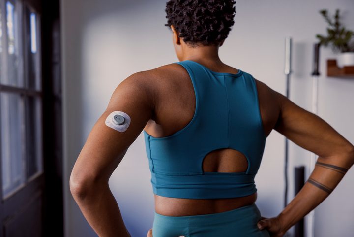 The Dexcom Stelo on the back of the arm of someone working out