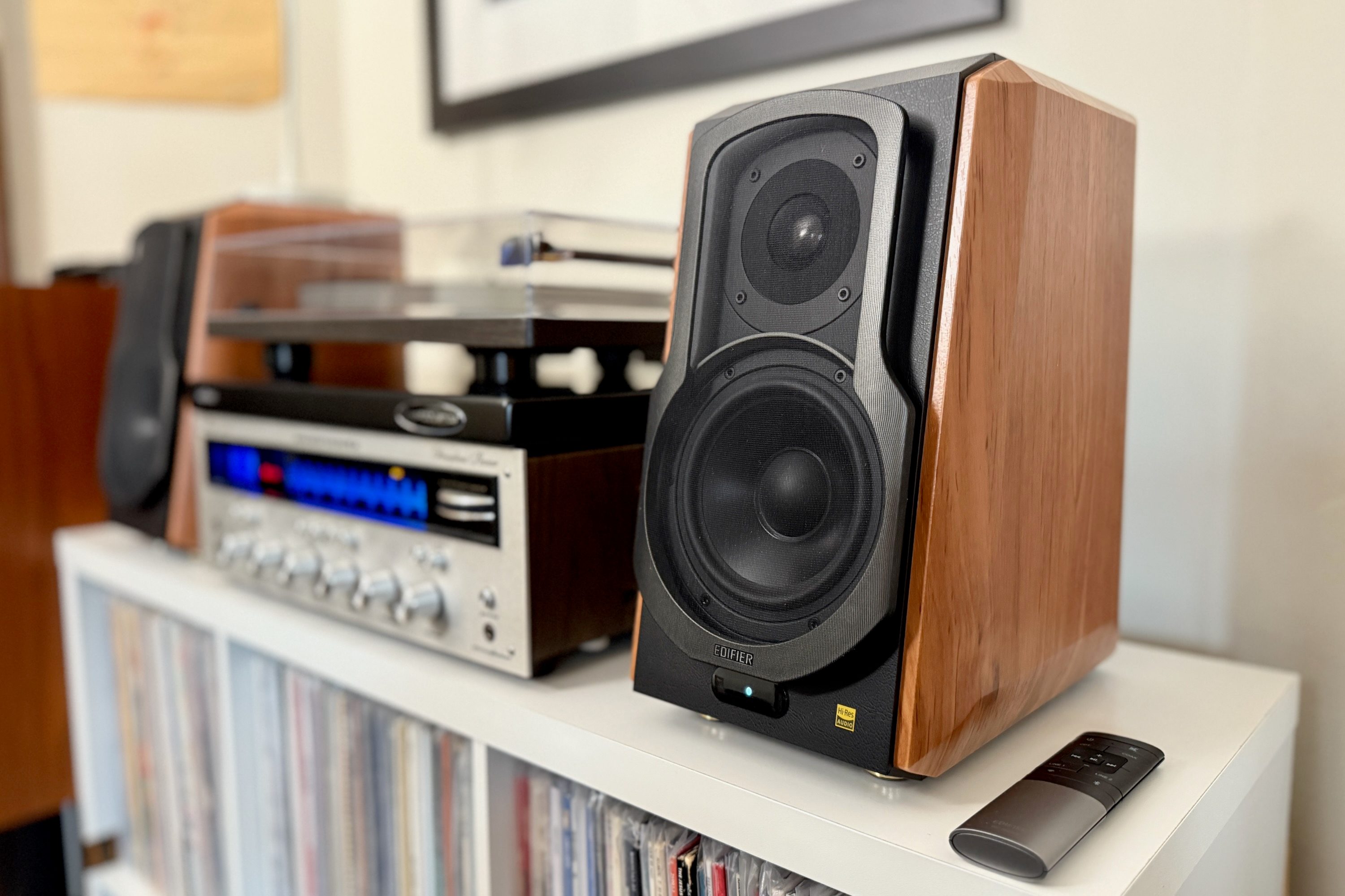 The Edifier S1000W bookshelf speakers on a shelf with a Marantz receiver and a record player.