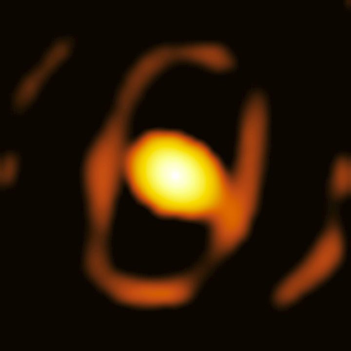 This is an image of the star WOH G64, taken by the GRAVITY instrument on the European Southern Observatory’s Very Large Telescope Interferometer (ESO’s VLTI). This is the first close-up picture of a star outside our own galaxy, the Milky Way. The star is located in the Large Magellanic Cloud, over 160 000 light-years away. The bright oval at the centre of this image is a dusty cocoon that enshrouds the star. A fainter elliptical ring around it could be the inner rim of a dusty torus, but more observations are needed to confirm this feature.