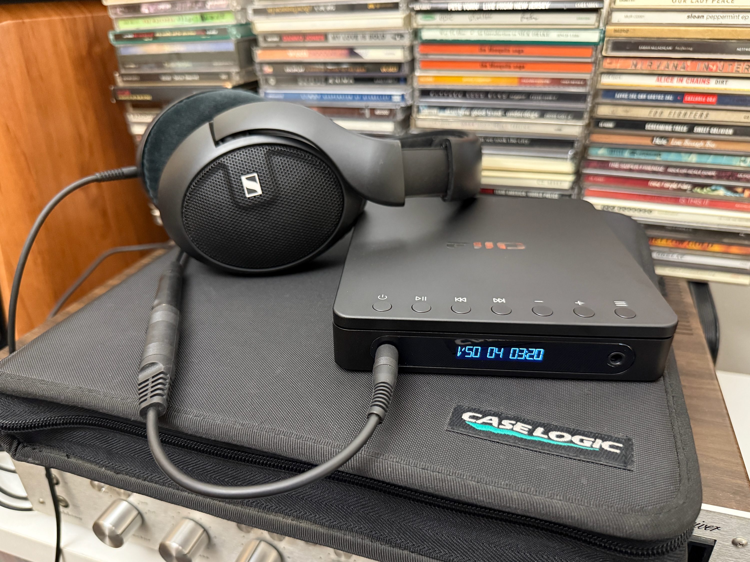 The Fiio dm13 Portable Stereo CD player connected to a pair of Sennheiser wired headphones.