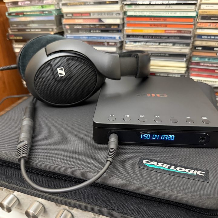 The Fiio dm13 Portable Stereo CD player connected to a pair of Sennheiser wired headphones.