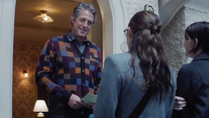 A man greets two girls at his door in Heretic.