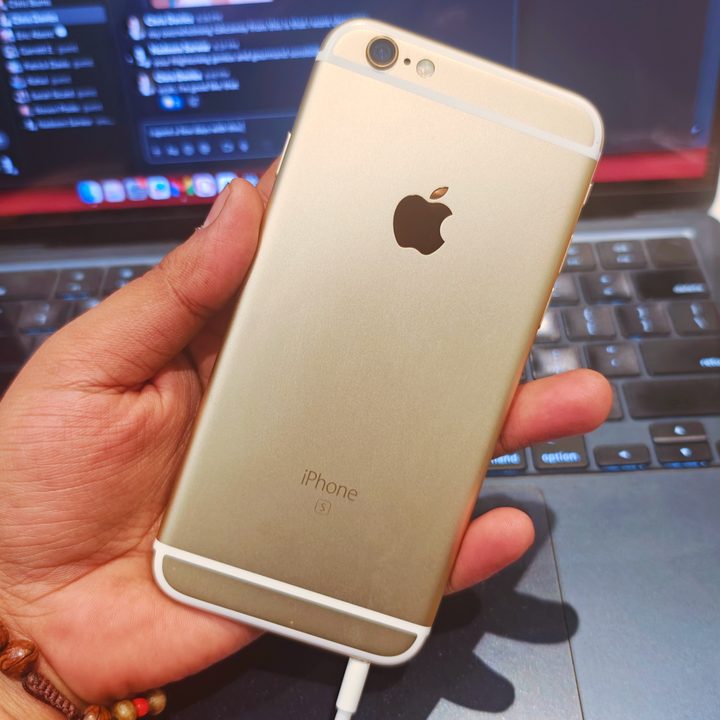 A gold iPhone 6S in the hands of a user.