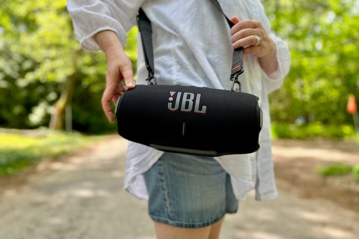 The JBL Xtreme 4 Bluetooth speaker on its shoulder strap.