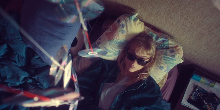 A woman sleeps underneath CD discs in Meanwhile on Earth.