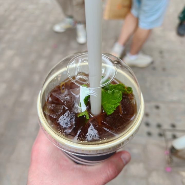 A photo of someone holding an iced coffee, taken with the Oppo Find X8.