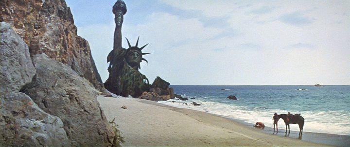A man collapses on a beach in Planet of the Apes.