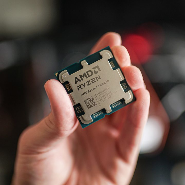 The Ryzen 7 9800X3D held between fingertips.