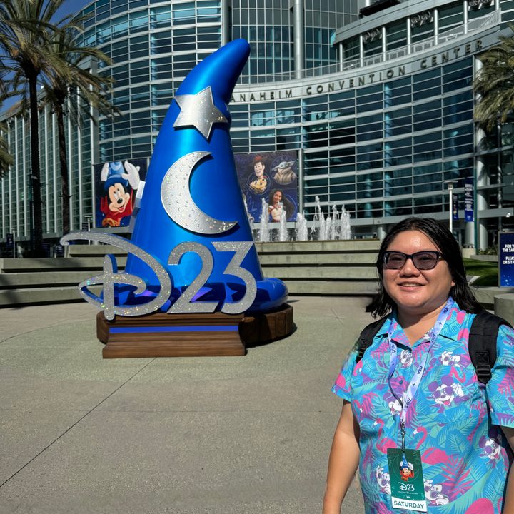 A person standing in front of the D23 display at Anaheim Convention Center.