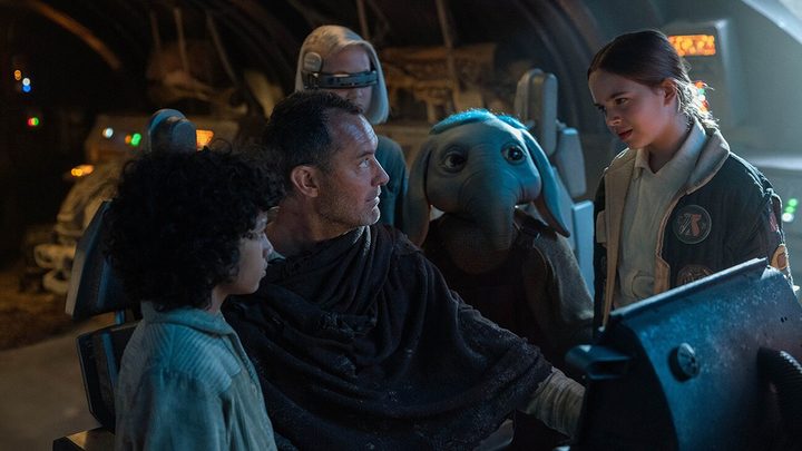 Jude Law surrounded by kids and a creature in Star Wars: Skeleton Crew.