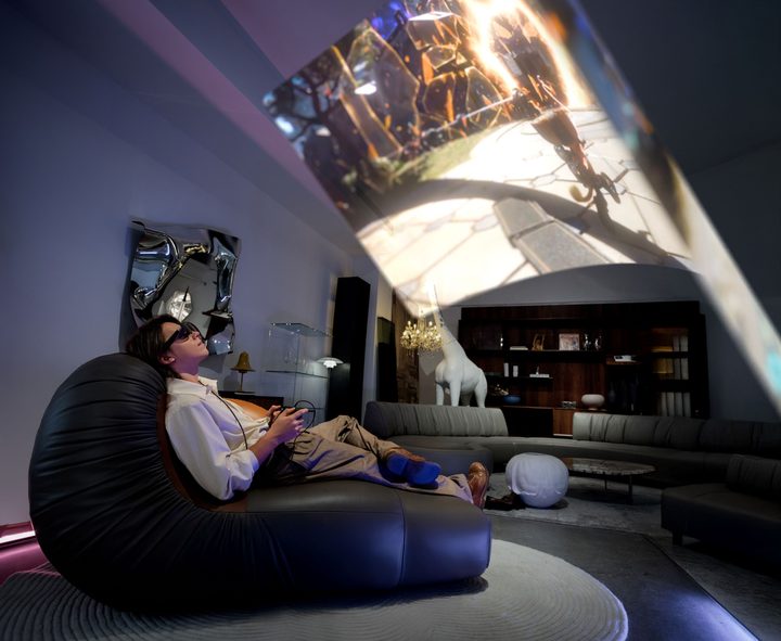 A person uses the Xreal One glasses to game in widescreen mode.