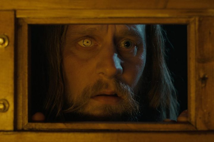 A man looks through a door's window in Oddity.