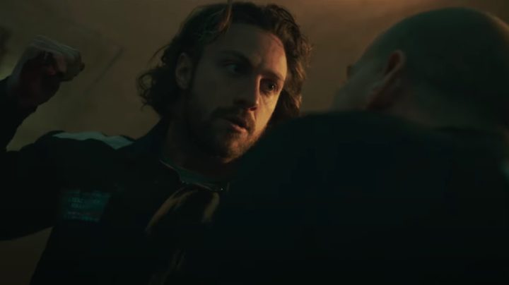 Aaronn Taylor-Johnson holds a weapon and goes to stab someone.