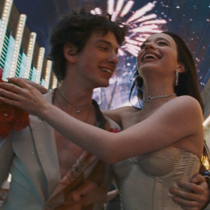 Mark Eydelshteyn and Mikey Madison dance against a blur of Las Vegas lights in a shot from the movie Anora.