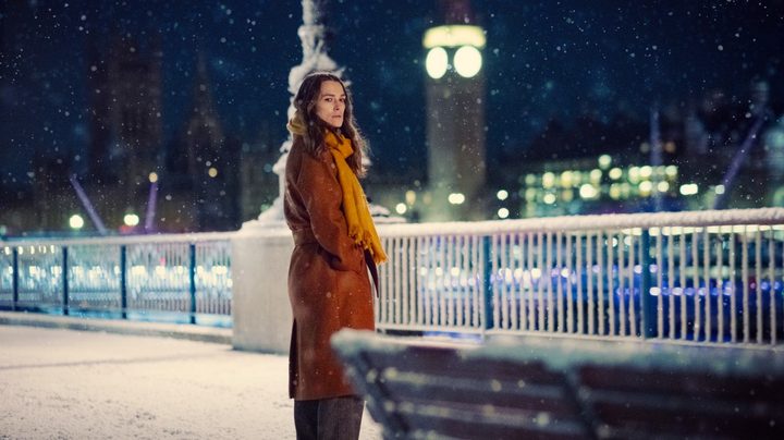 A woman stands on a bridge in Black Doves.