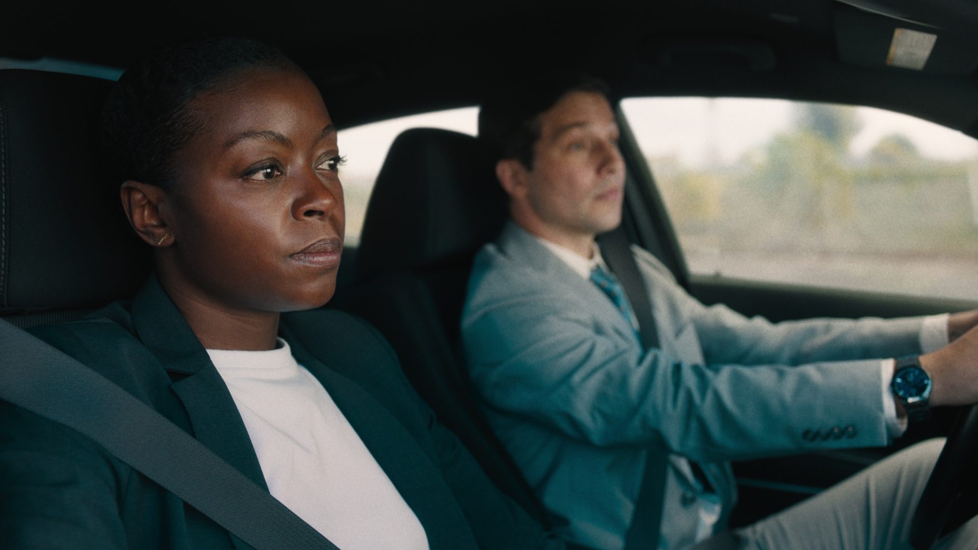 A woman sits in the passenger seat as the man drives in Carry-On.