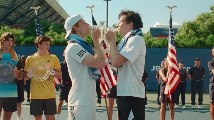 Two men kiss their trophies in Challengers.