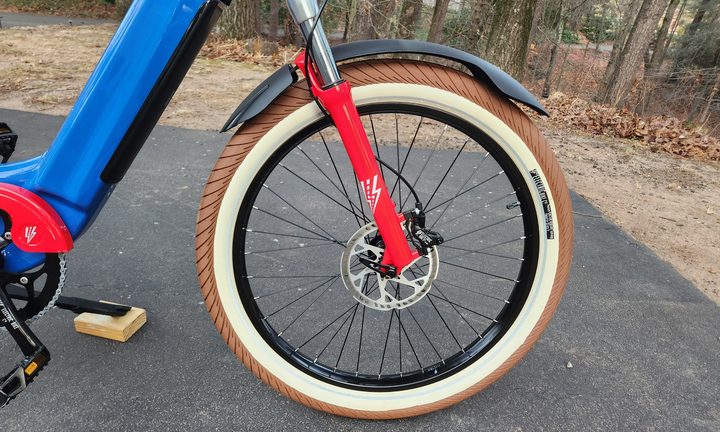 Electric Bike Company Model R right profile view of front wheel showing thru axle and front disc brake and brake rotor.