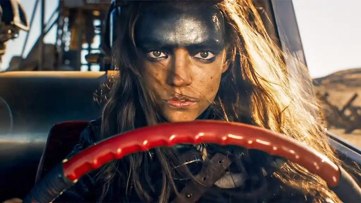 Furiosa sits behind the wheel in Furiosa.