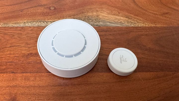 The Flic Twist and Flic Smart Buttons on a wooden table.