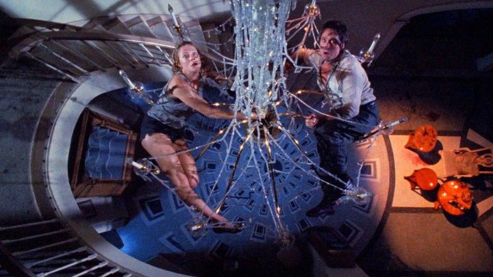Kathleen Turner and Michael Douglas as Barbara and Oliver Rose hanging from a chandelier in The War of the Roses.