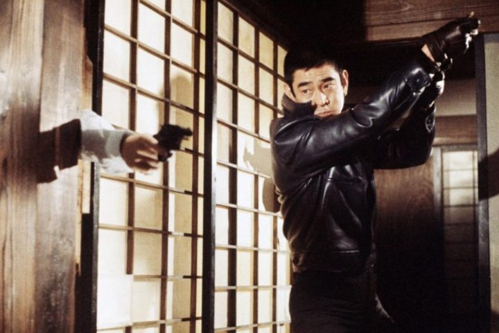 Ken Takakura looks at a gun in The Yakuza.