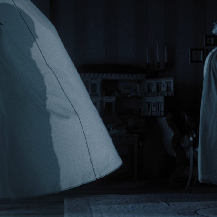 Lily-Rose Depp floats in front of billowing window curtains in "Nosferatu."