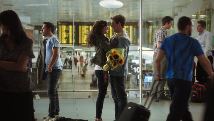 A woman and a man embrace in an airport in Love Rosie.