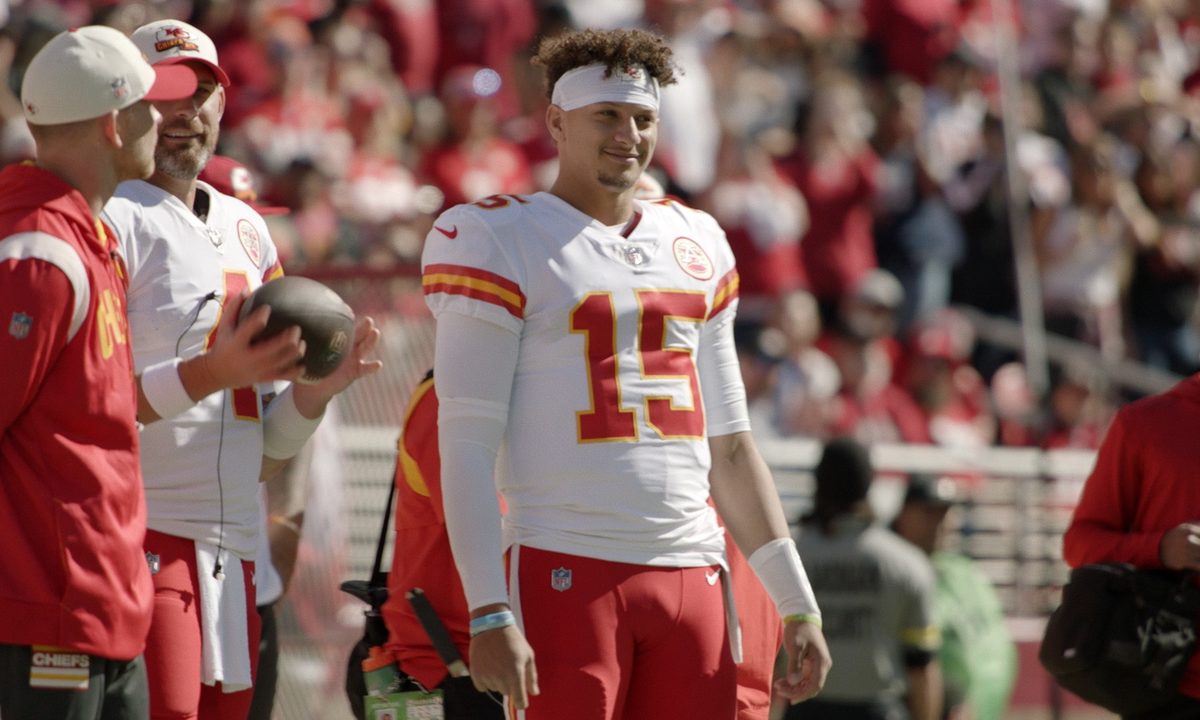Patrick Mahomes stands on the sidelines for the Chiefs.