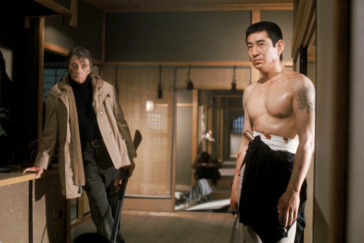 Robert Mitchum stands near Ken Takakura in The Yakuza.