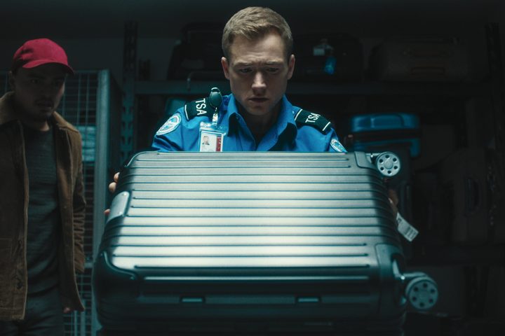 A man looks at a suitcase in Carry-On.