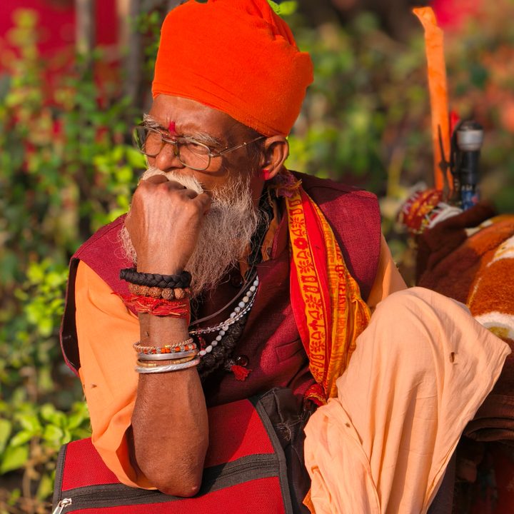 Old Indian sage wearing a saffron colored robe and headgear captured with the Vivo X200 Pro.