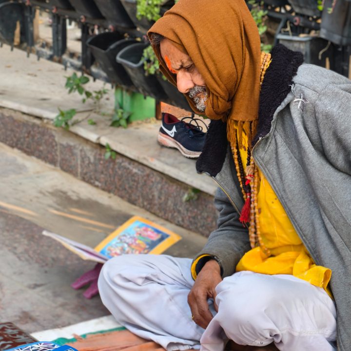 Religious old man sitting on the sidewalk captured with the Vivo X200 Pro.